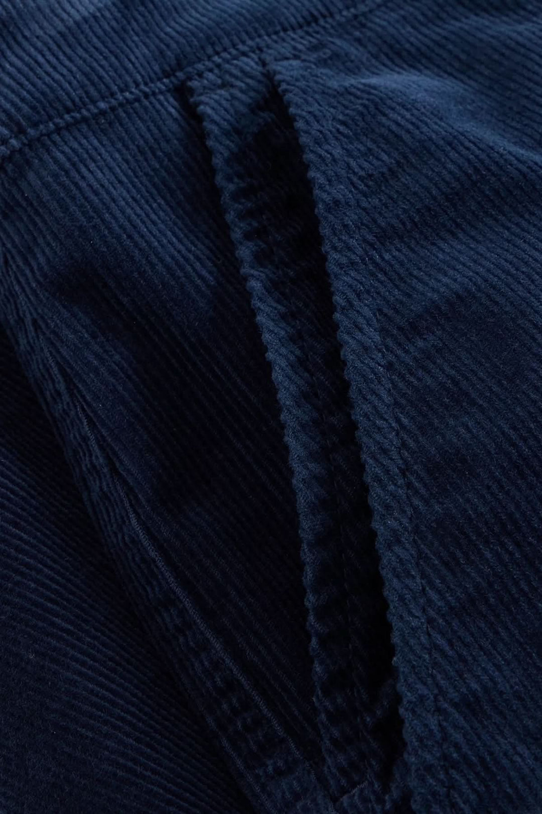 Zoom sur le tissu en velours côtelé bleu du pantalon Twister, montrant la texture et les détails de couture.