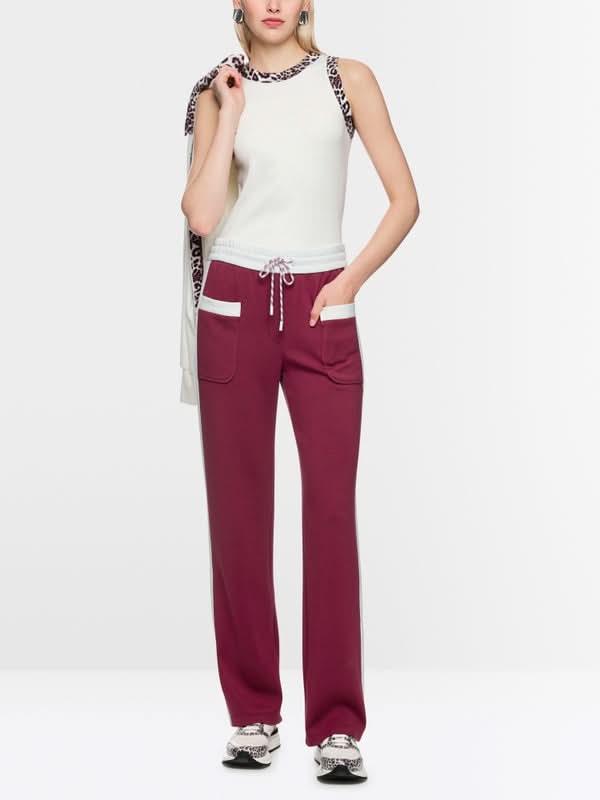 Femme portant le pantalon à enfiler Washington bordeaux avec taille jogging et poches, détails rayures contrastées.