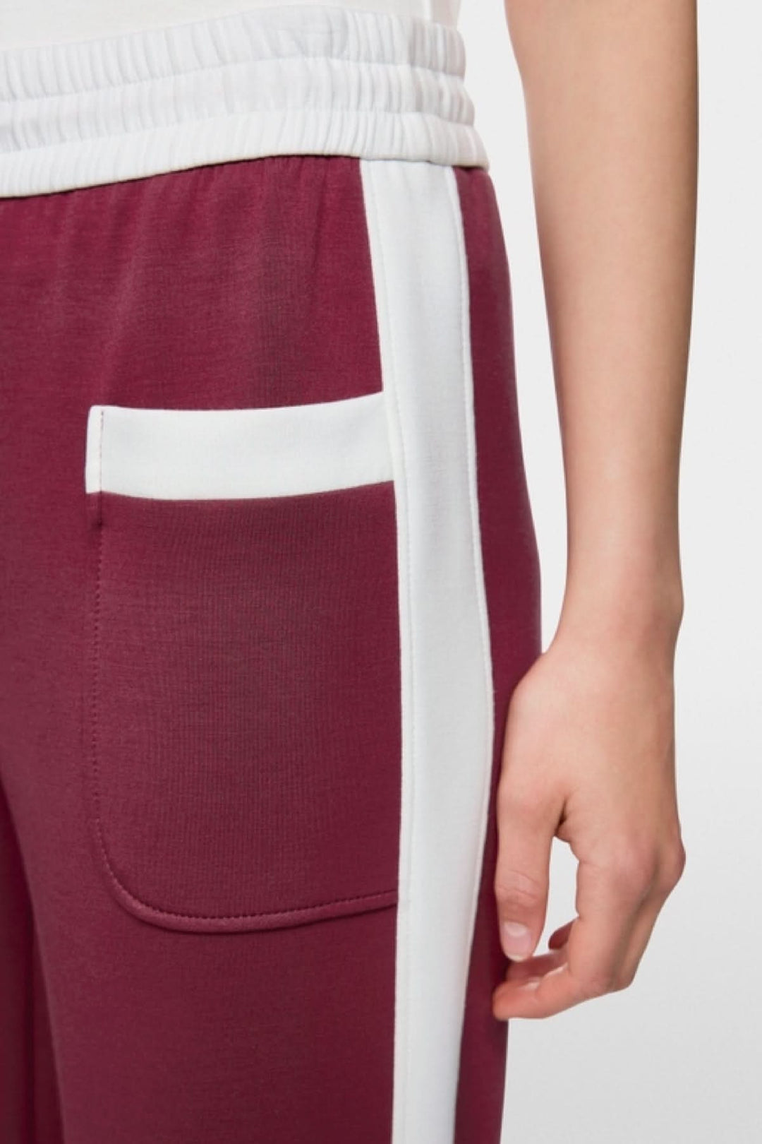 Gros plan sur le pantalon à enfiler Washington avec taille élastique et rayures contrastées blanc sur rouge, poches latérales visibles.