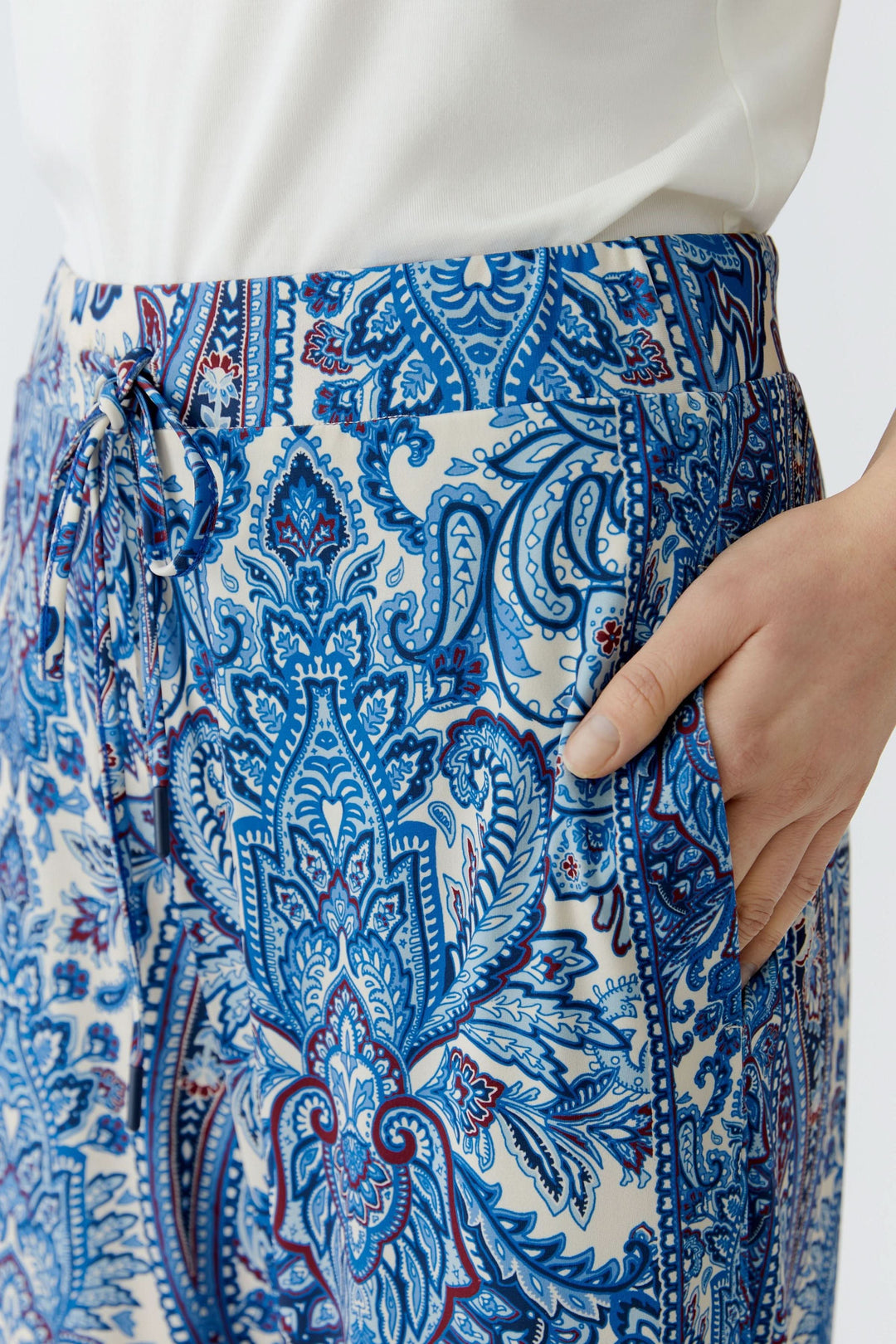 Détail du pantalon fluide à imprimé cachemire, montrant un motif bohème bleu et coupe droite élégante.