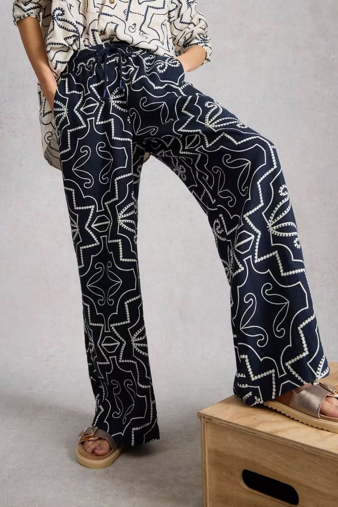 Pantalon fluide imprimé à jambe large avec imprimé graphique et coupe ample. Élégant et confortable, parfait pour un look sophistiqué.