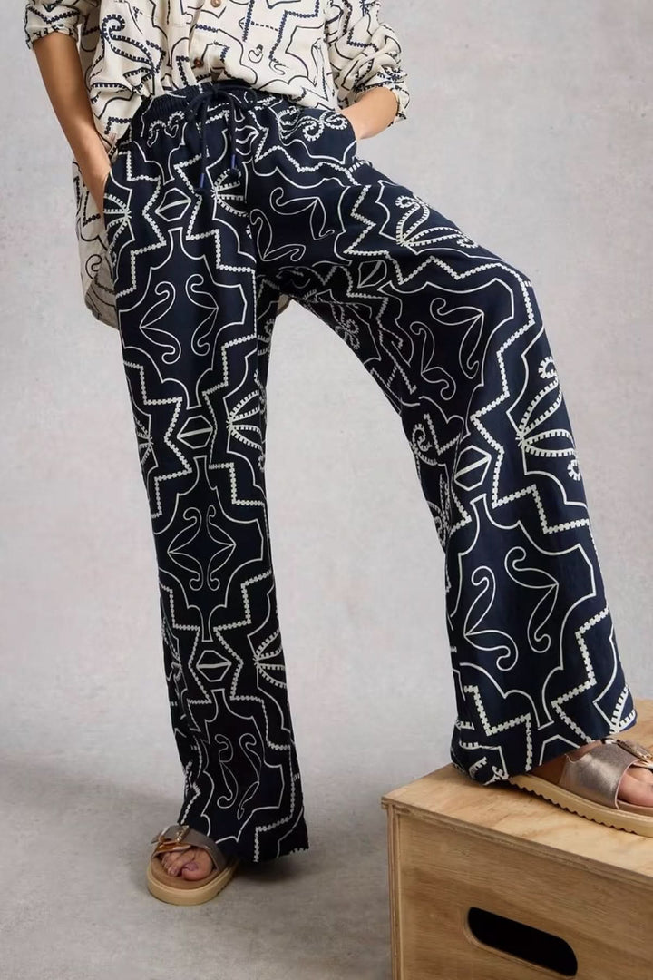 Pantalon fluide imprimé à jambe large avec imprimé graphique et coupe ample. Élégant et confortable, parfait pour un look sophistiqué.