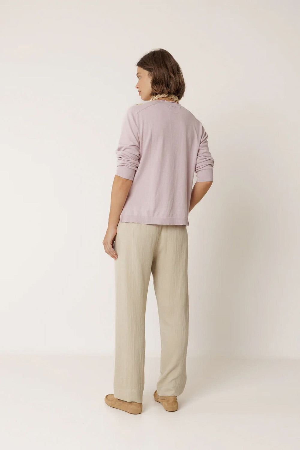 Vue arrière d'un pantalon fluide à taille élastique beige, porté avec un haut lavande.