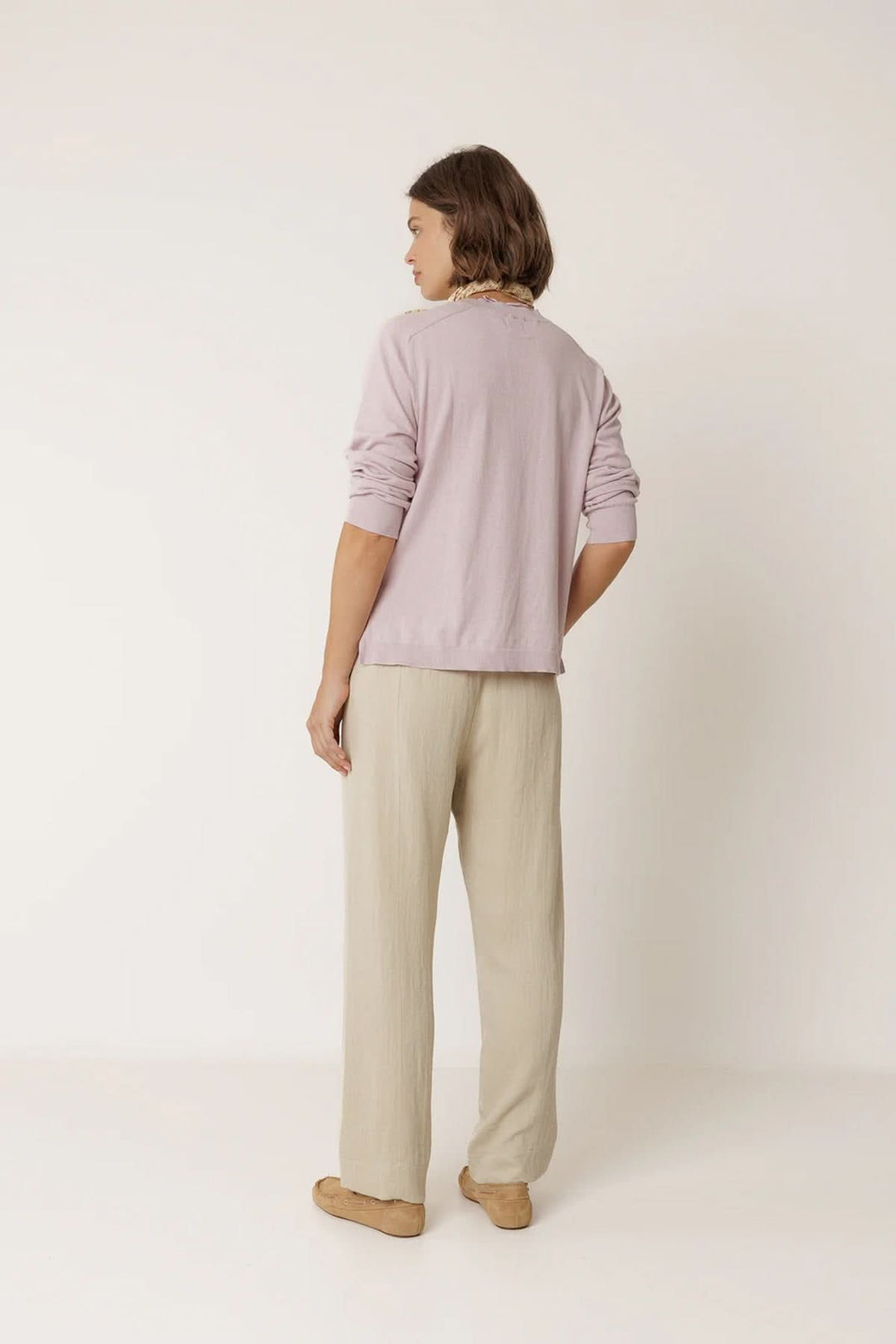 Vue arrière d'un pantalon fluide à taille élastique beige, porté avec un haut lavande.