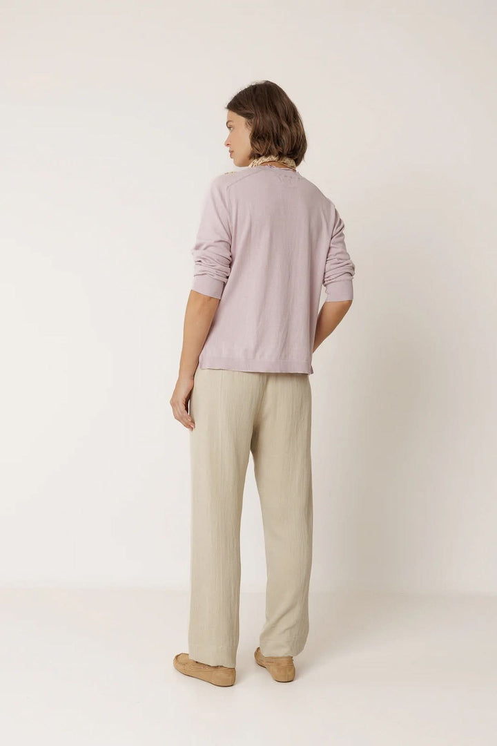 Vue arrière d'un pantalon fluide à taille élastique beige, porté avec un haut lavande.