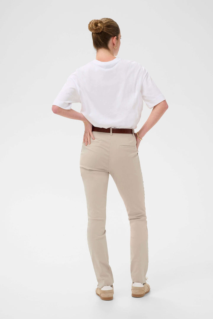 Pantalon habillé Hazel beige porté avec ceinture marron, vue arrière. Coupe ajustée idéale pour un style professionnel et formel.