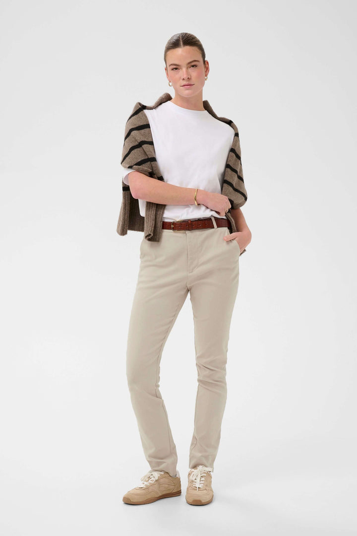 Femme portant un Pantalon habillé Hazel beige avec coupe ajustée, parfait pour un style professionnel ou occasion formelle.