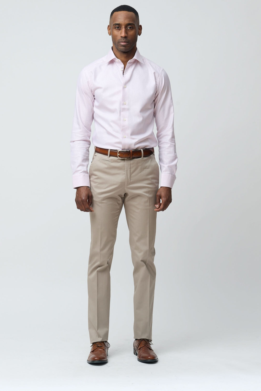 Homme portant un pantalon habillé coupe ajustée avec chemise et ceinture marron, idéal pour un look élégant et professionnel.