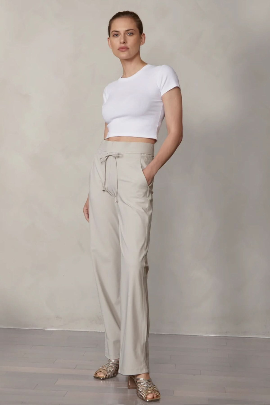 Femme portant pantalon habillé droit Candice avec taille élastique et poches, coupe élégante parfaite pour le travail et occasions formelles.