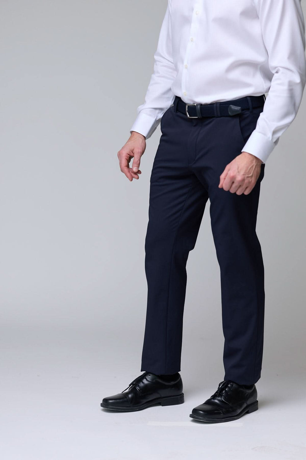 Homme portant un pantalon habillé extensible bleu marine, associé à une chemise blanche pour un look professionnel.
