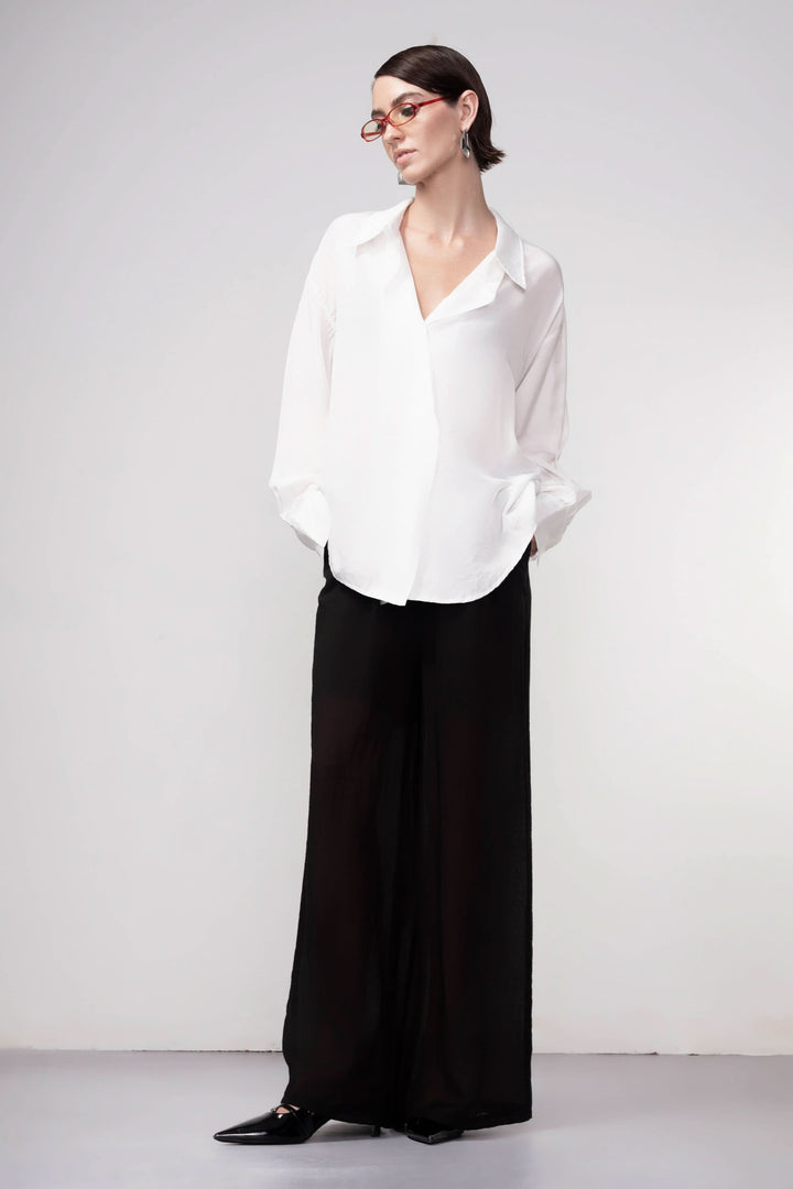 Pantalon jambe large noir avec taille élastique, coupe fluide. Parfait pour une tenue décontractée ou élégante. Mode moderne femme.