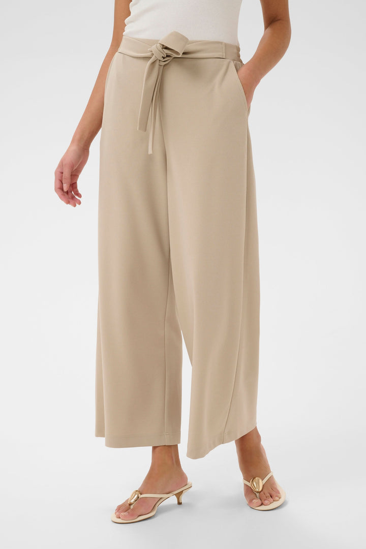 Pantalon jambe large Phoebe beige avec ceinture intégrée, silhouette élégante et fluide. Taille mi-haute, look raffiné polyvalent.