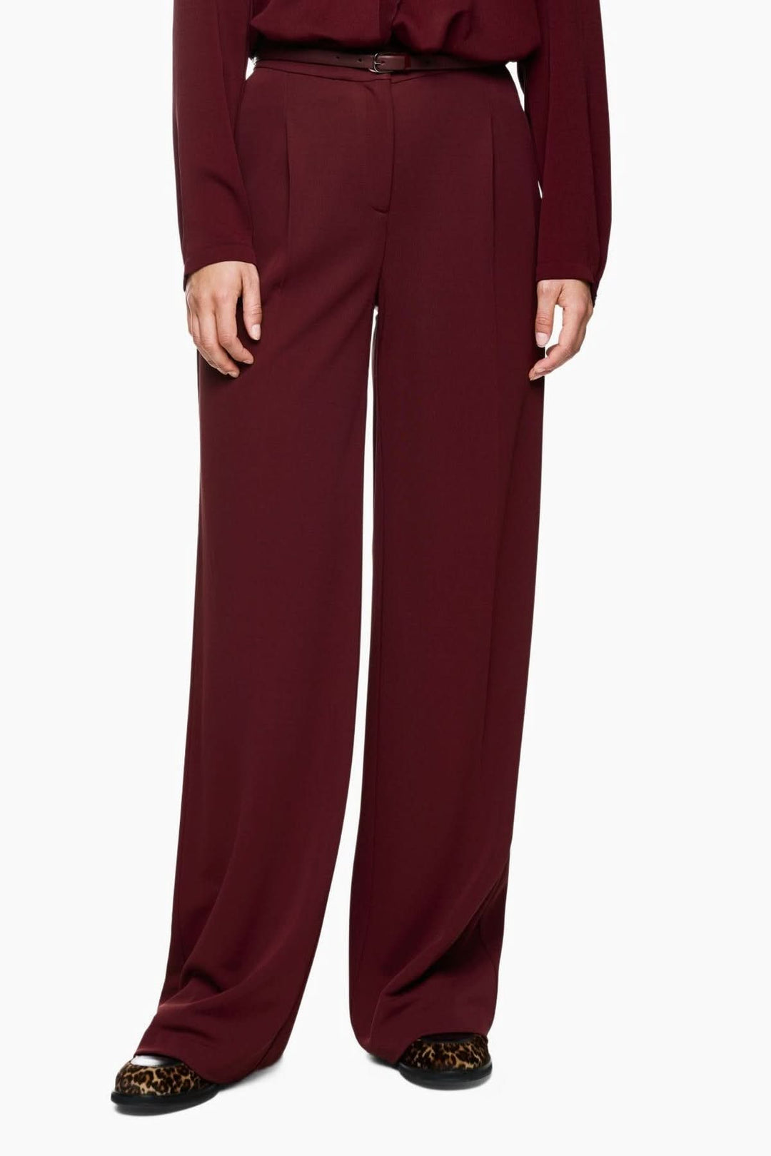 Pantalon jambes larges élégant, matière fluide, taille haute structurée et plis marqués pour silhouette raffinée.