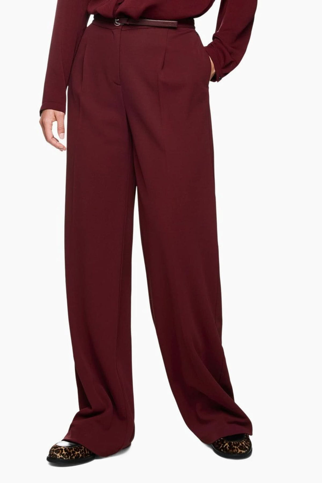 Pantalon jambes larges élégant en tissu fluide, taille haute avec plis marqués, offrant confort et style raffiné.