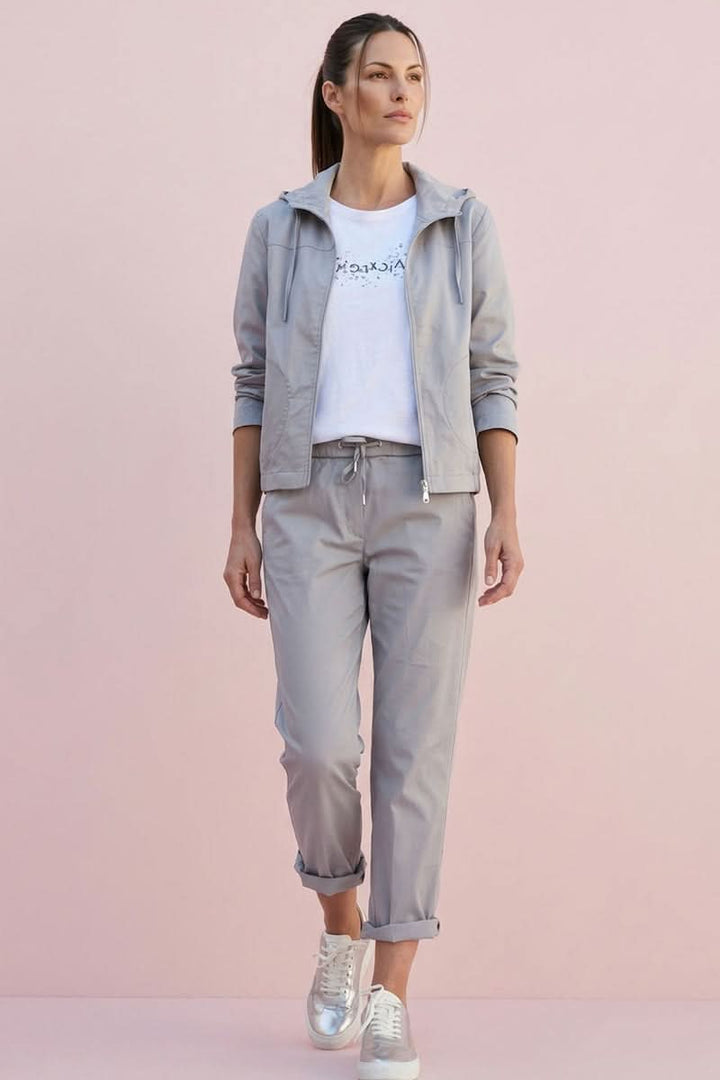 Femme portant un pantalon jogger à cordon gris avec veste, style décontracté moderne.