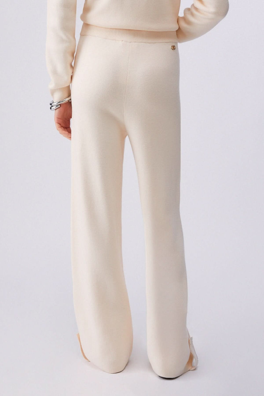 Pantalon jogging en maille à jambe large couleur crème, vue arrière, coupe fluide et taille élastique avec cordon de serrage.