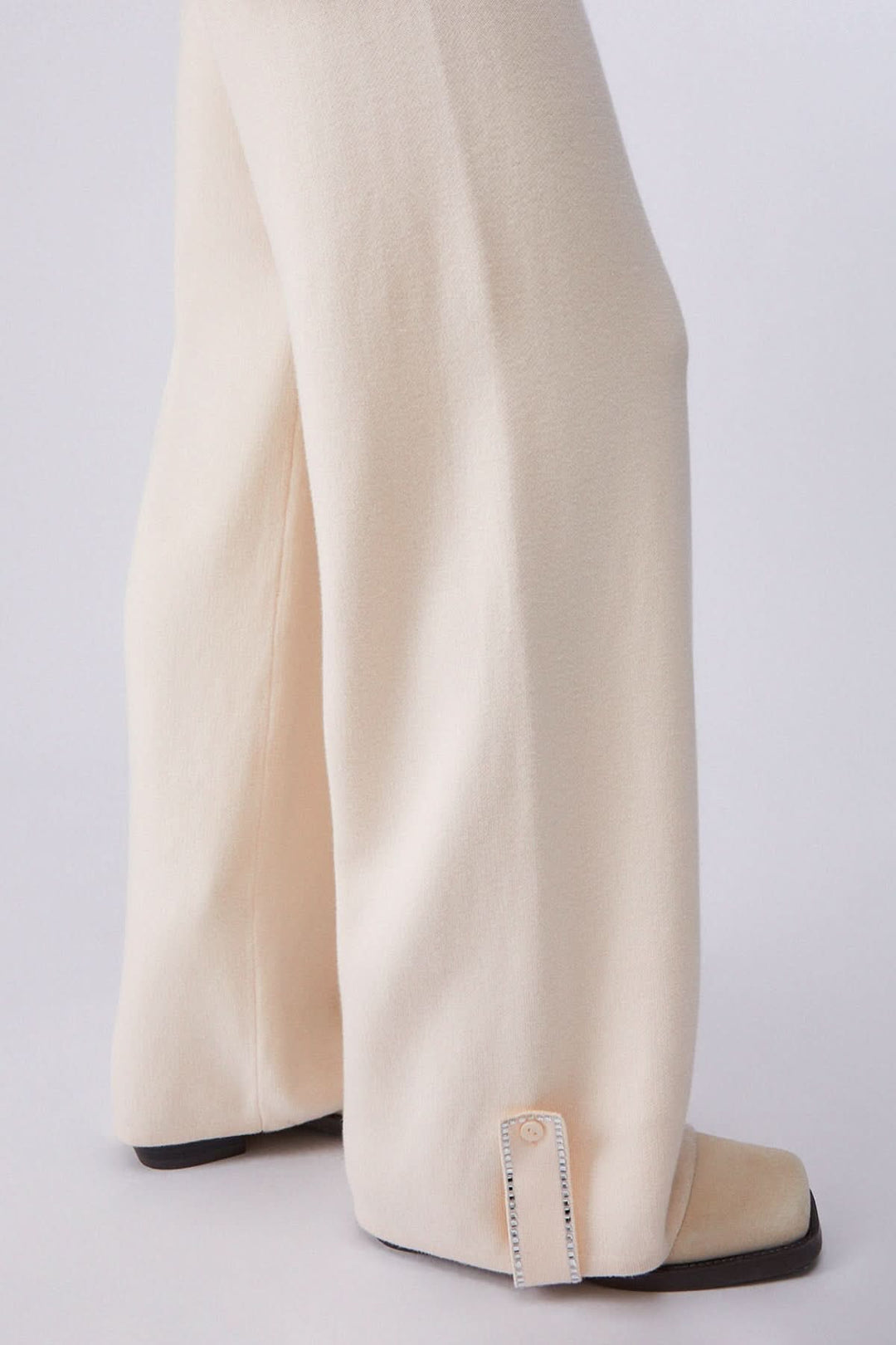 Pantalon jogging en maille à jambe large en beige avec jambe fluide et élégante, vue de côté.