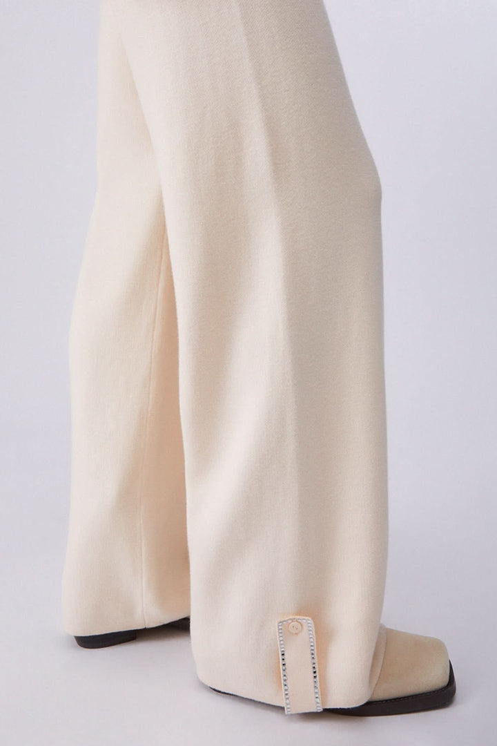 Pantalon jogging en maille à jambe large en beige avec jambe fluide et élégante, vue de côté.