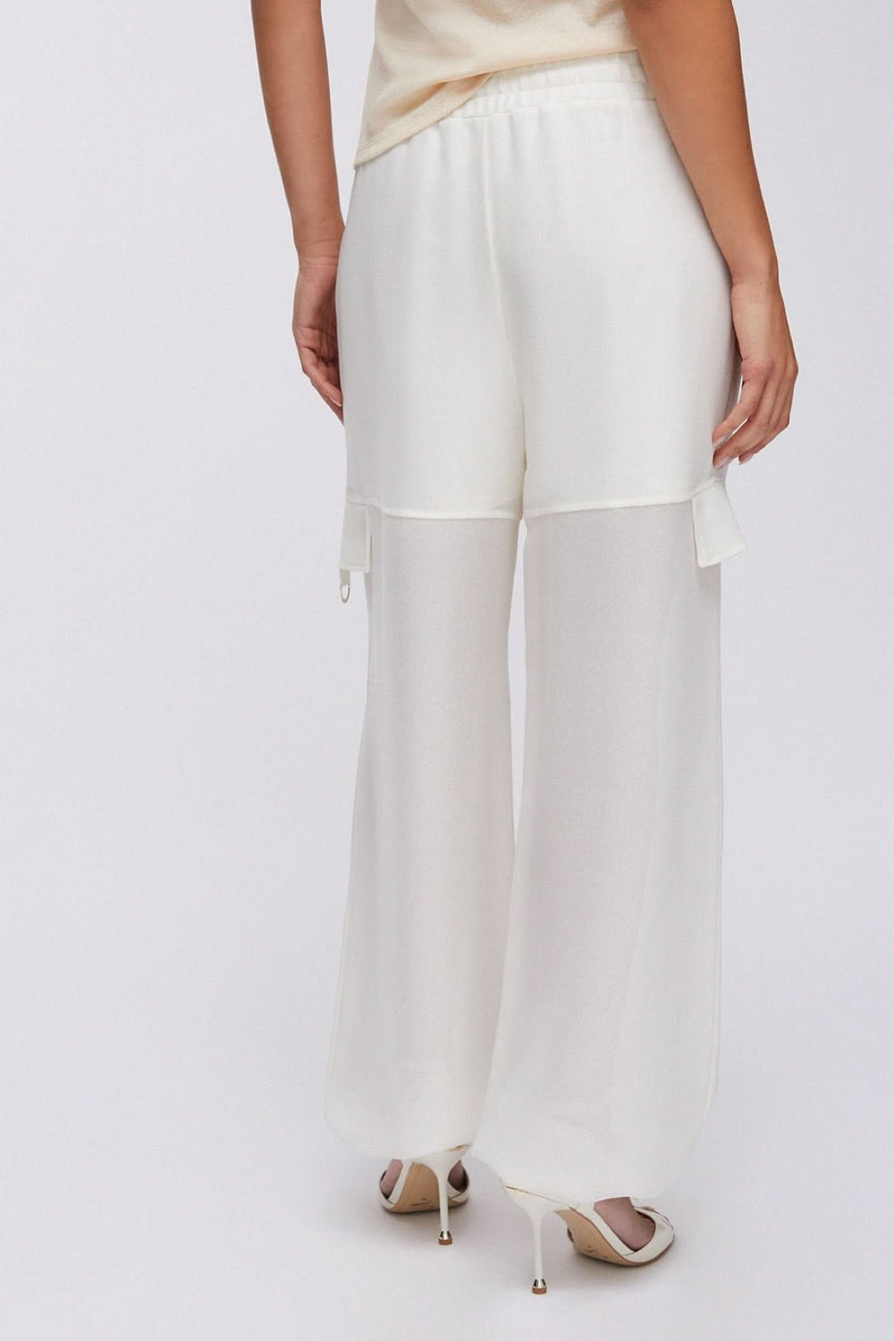 Dos d'un pantalon jogging large à cordon blanc, ample et fluide, avec taille élastique et empiècements style cargo.