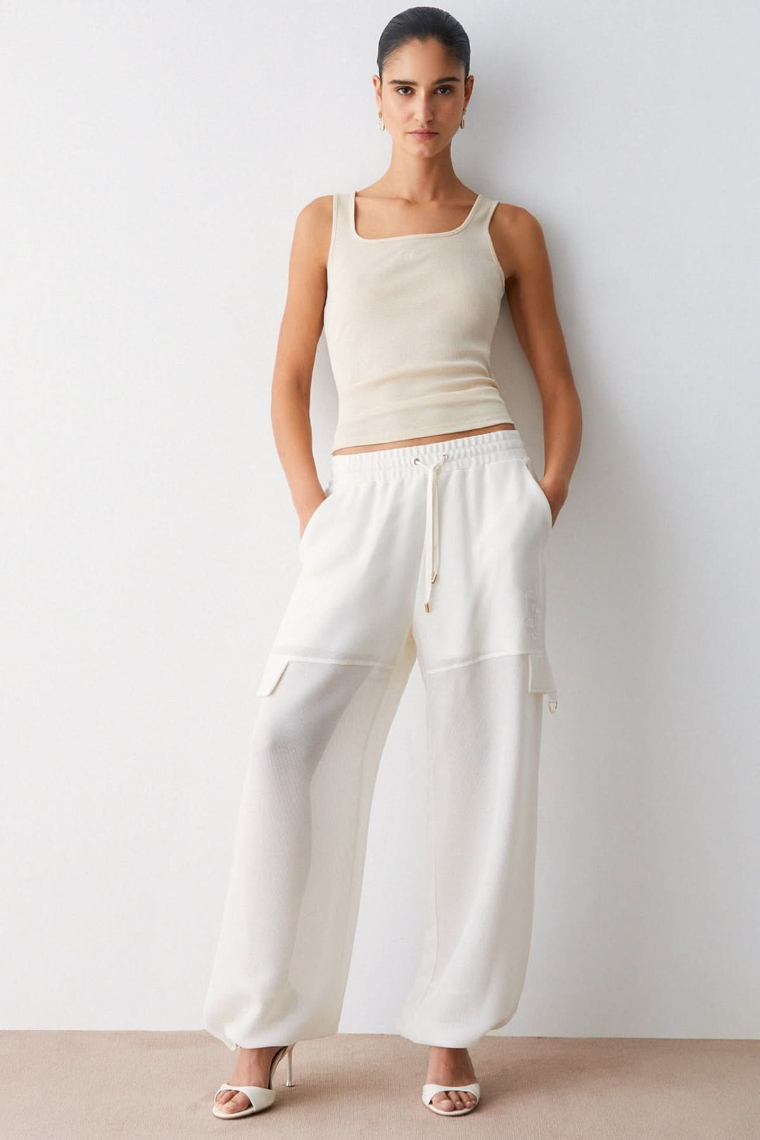 Pantalon jogging large à cordon ample blanc avec taille élastique et poches latérales, modèle moderne et fluide, style décontracté.