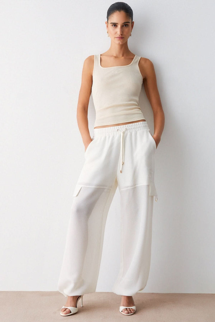 Pantalon jogging large à cordon ample blanc avec taille élastique et poches latérales, modèle moderne et fluide, style décontracté.