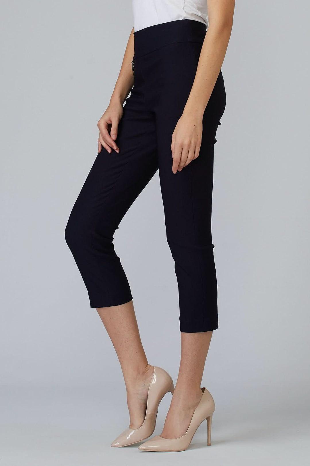 Pantalon à la cheville ajusté, confortable, en noir, avec taille extensible et longueur 7/8, porté avec des escarpins.
