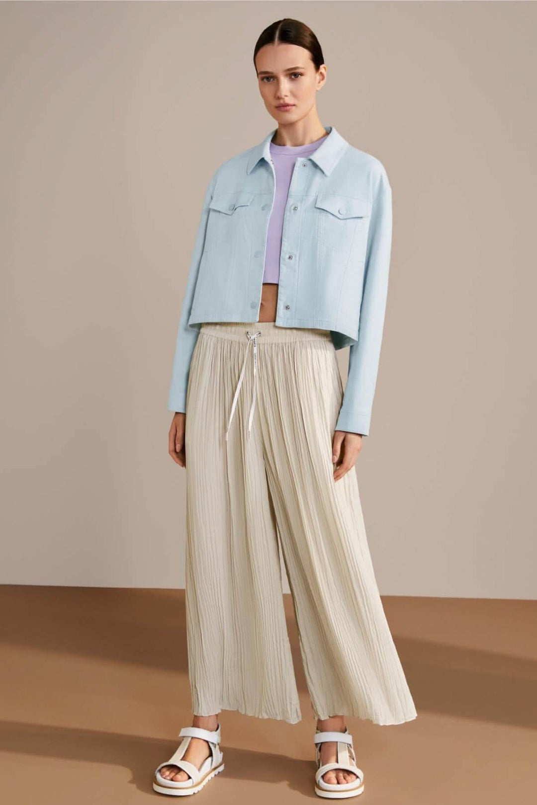 Femme portant un pantalon large WOLIN beige et une veste en denim bleue, style décontracté et élégant.