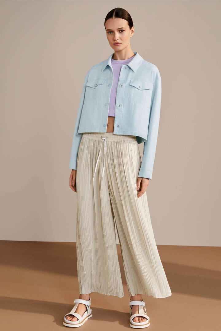 Femme portant un pantalon large WOLIN beige et une veste en denim bleue, style décontracté et élégant.