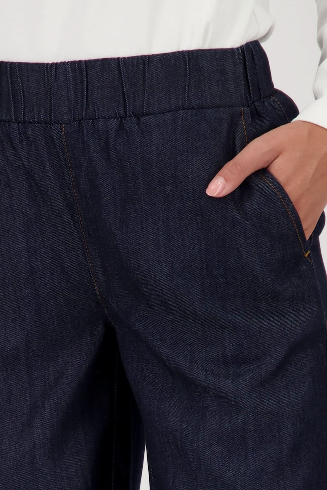 Pantalon large en denim avec taille élastiquée et poches latérales, offrant confort et style décontracté.