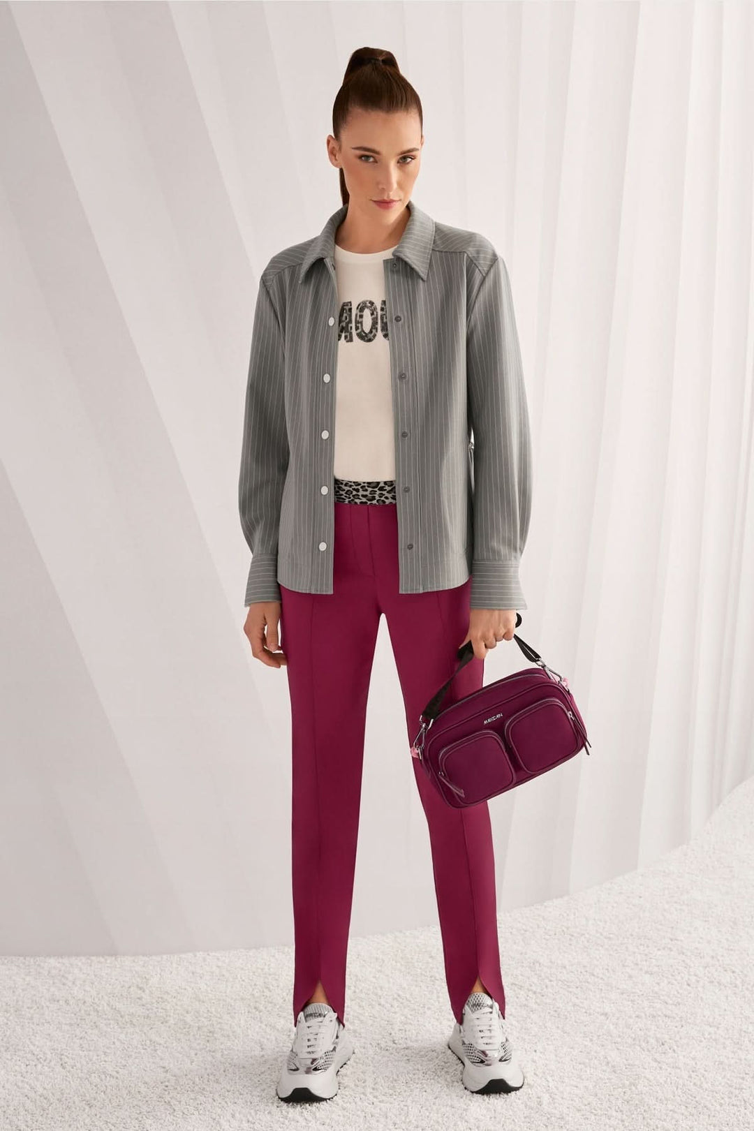 Femme portant le pantalon pull-on SIENA coupe slim avec fente avant, style élégant et confort, accompagnée d'un sac à main et d'une chemise.
