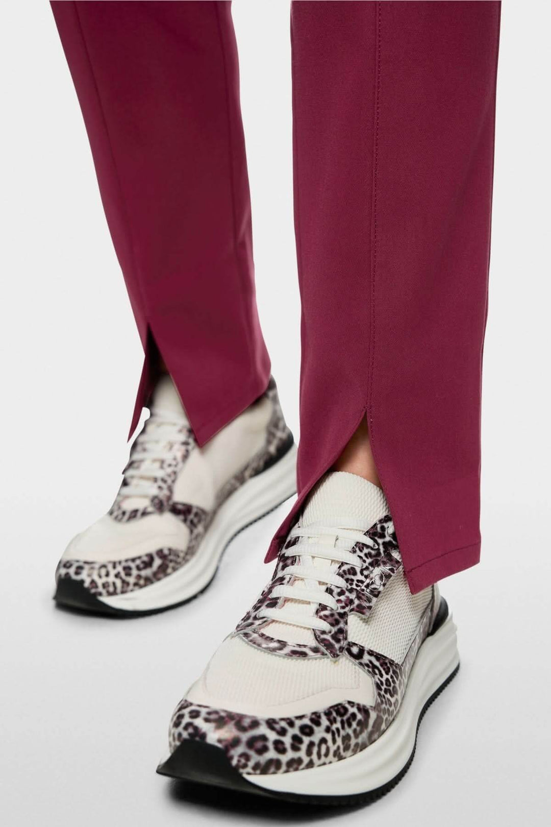 Pantalon pull-on SIENA coupe slim avec fente avant, porté avec des baskets imprimées léopard.