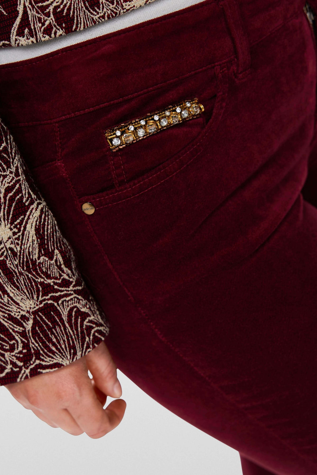 Pantalon taille basse en velours bordeaux avec détail de strass sur la poche, pour un style élégant et raffiné.