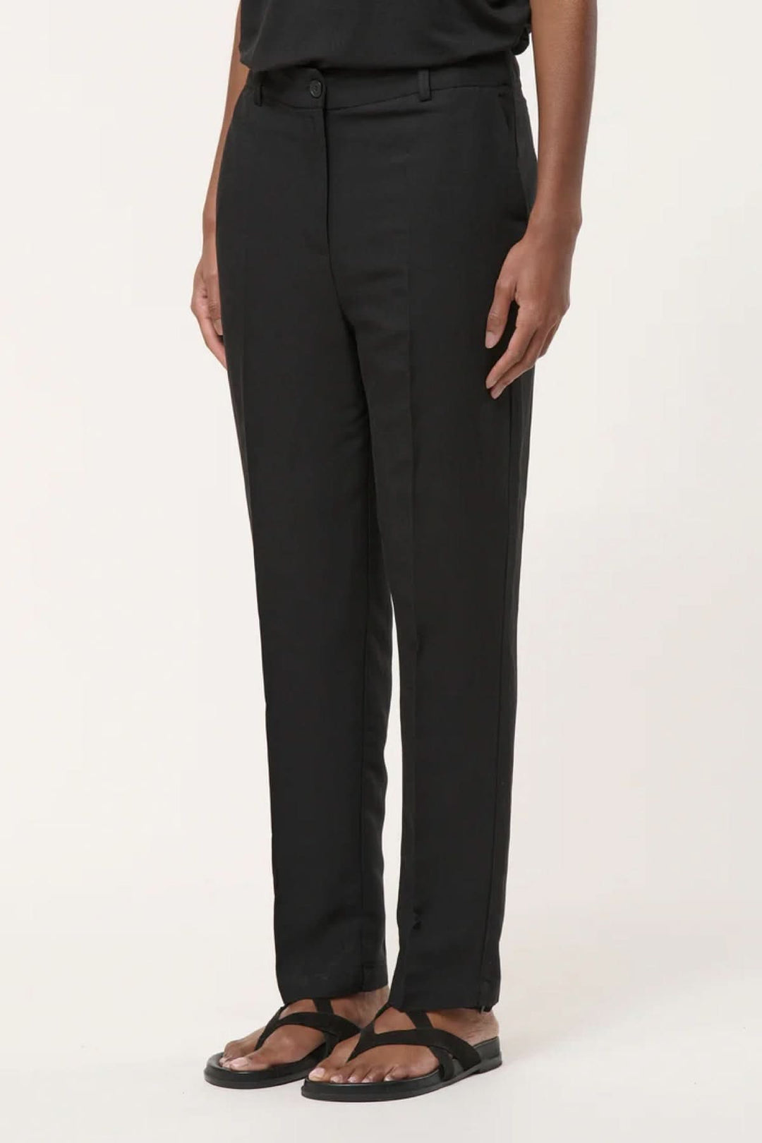 Pantalon tailleur coupe droite noir sur modèle, style élégant et intemporel pour bureau ou occasions habillées.