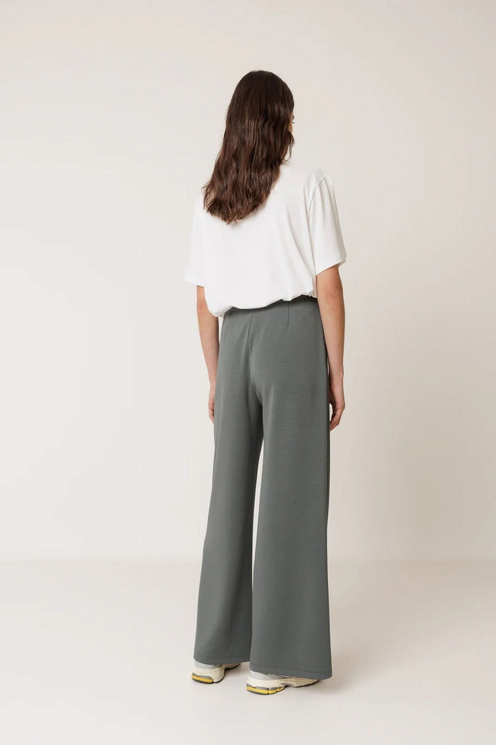Pantalon tailleur fluide à plis marqués vu de dos, coupe droite ample assurant confort et élégance moderne, idéal avec une tenue chic.