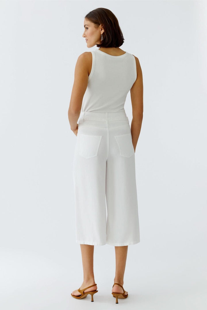 Femme portant un pantalon trois quarts à taille nouée blanc, coupe fluide, vue de dos, parfait pour l&