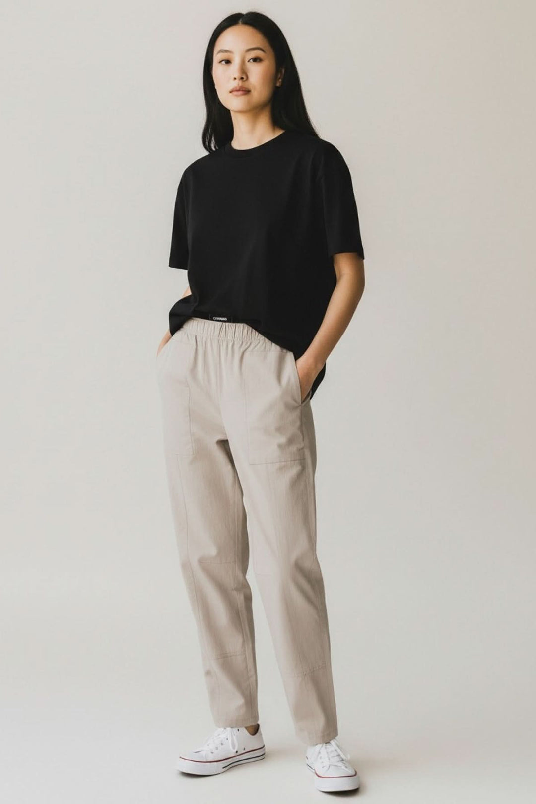 Femme portant le Pantalon utilitaire Ophelia avec coupe droite et poches appliquées, mise en scène minimaliste et moderne.