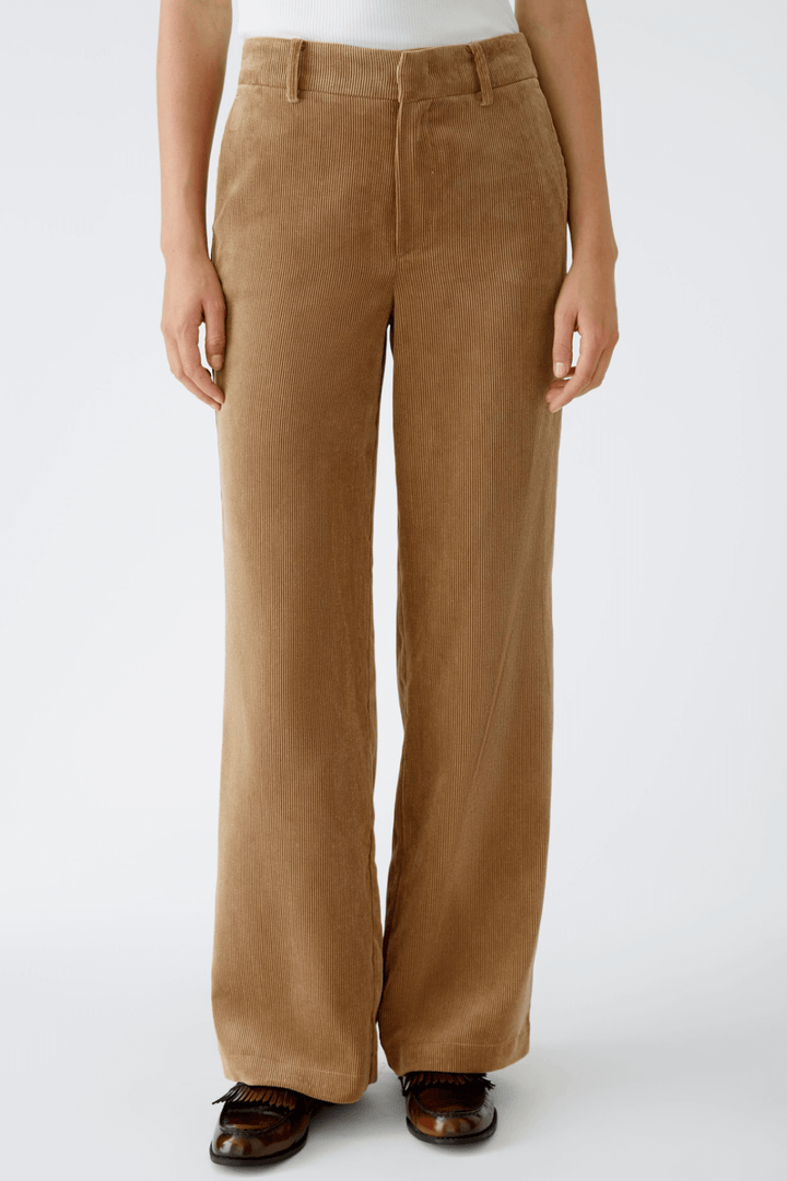 Pantalon en velours côtelé de couleur marron, coupe droite, taille moyenne et poches latérales pratiques.