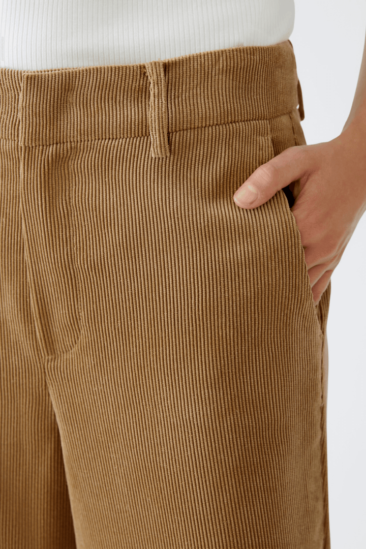 Pantalon en velours côtelé marron à coupe droite avec poches latérales, offrant confort et style.