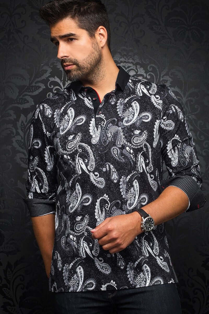 Homme portant un polo Ahmosis à motif cachemire noir et blanc, col contrastant et poignets ajustables.