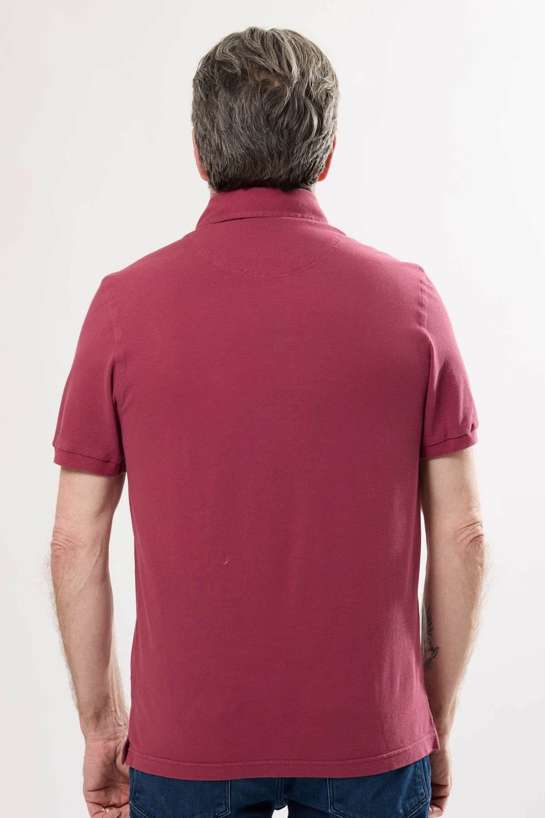 Polo classique homme vu de dos en coton doux, couleur unie, col en maille piquée et manches courtes.