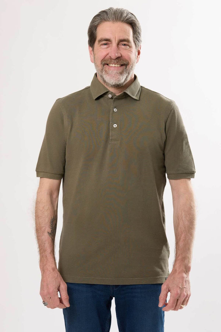 Homme portant un polo classique en coton doux, col en maille piquée, coloris uni, style décontracté.