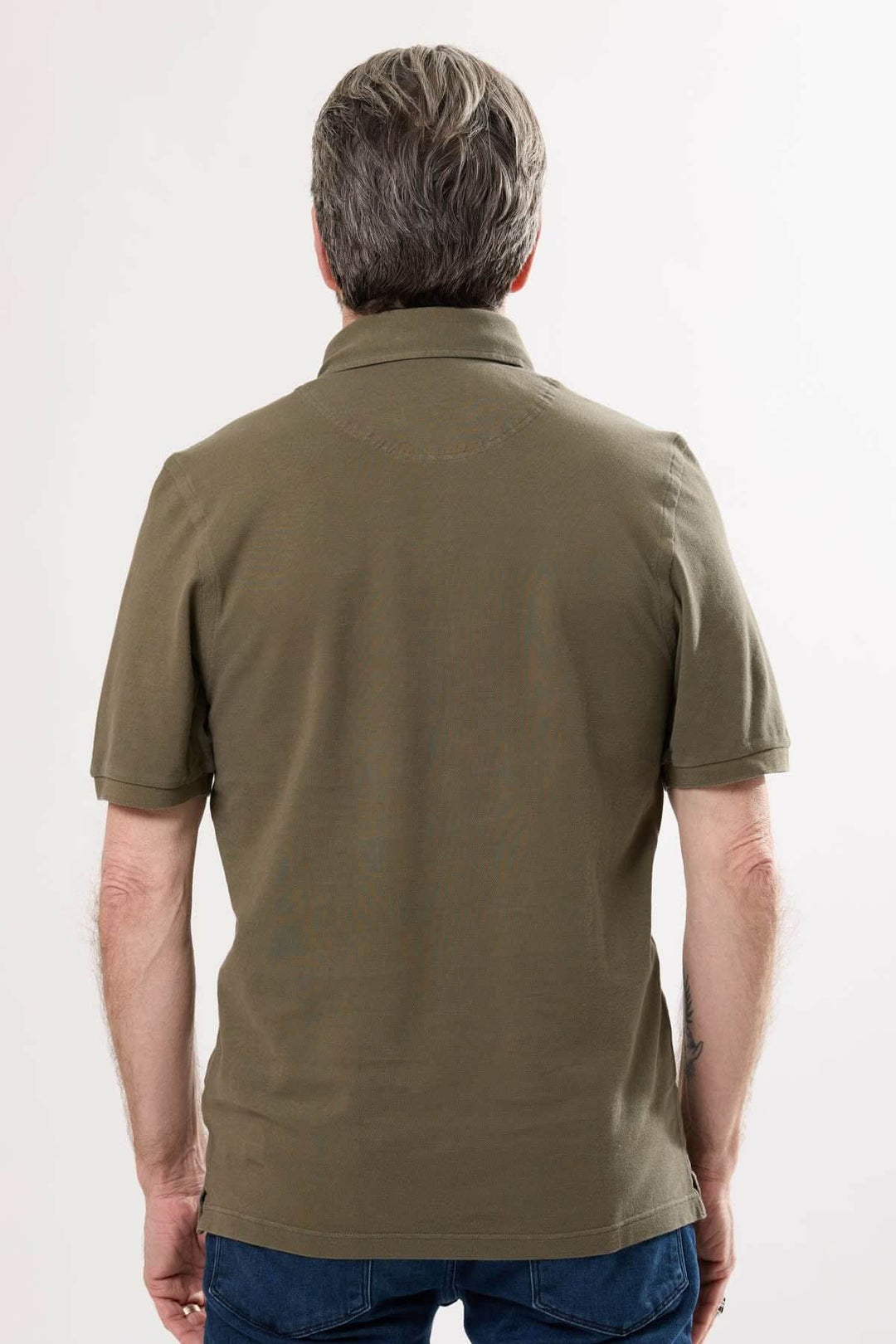 Homme portant un polo classique olive, vu de dos, avec col en maille piquée et manches courtes.