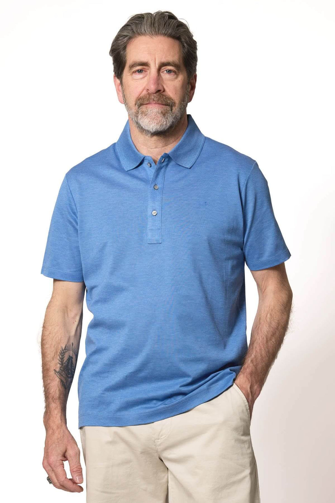 Homme portant un polo classique à manches courtes de couleur bleue, coupe confortable et look épuré.
