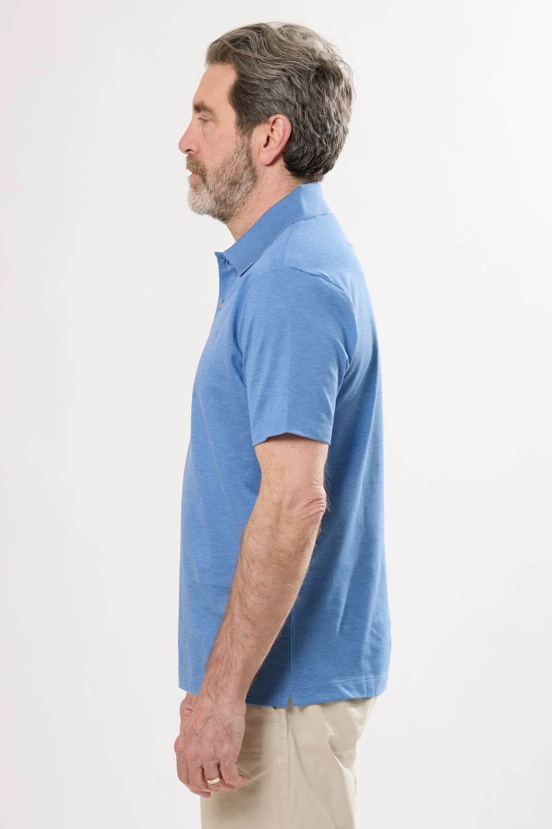 Homme portant un polo classique bleu à manches courtes, vue de profil, avec un col structuré.