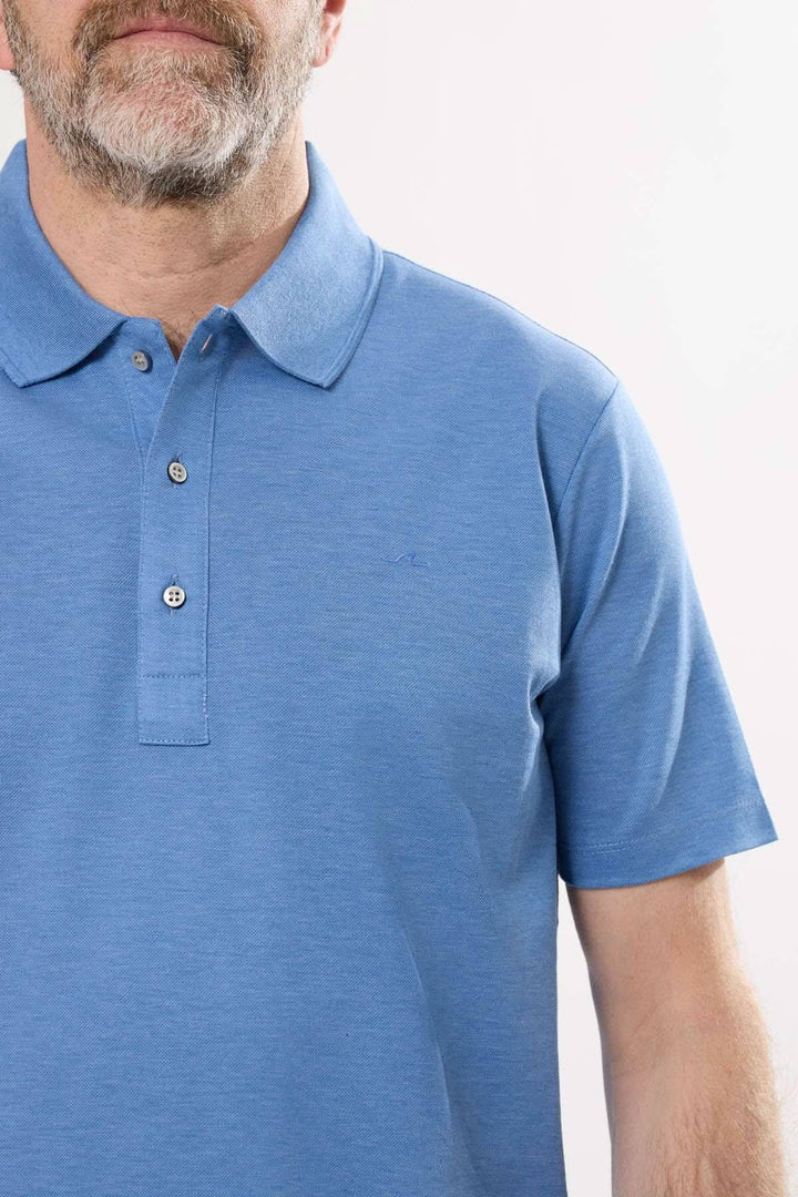 Homme portant un polo classique à manches courtes en coton bleu, col polo structuré avec boutons.
