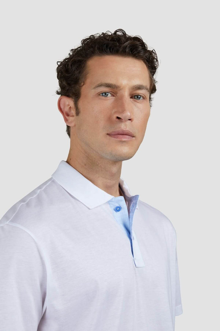 Homme portant un polo en coton léger avec col contrasté bleu, pour un look décontracté et sophistiqué.