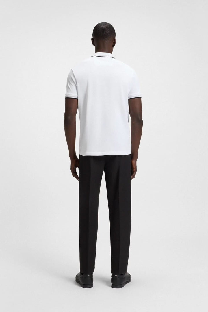 Homme portant un polo minimaliste blanc avec finitions contrastantes, vu de dos.