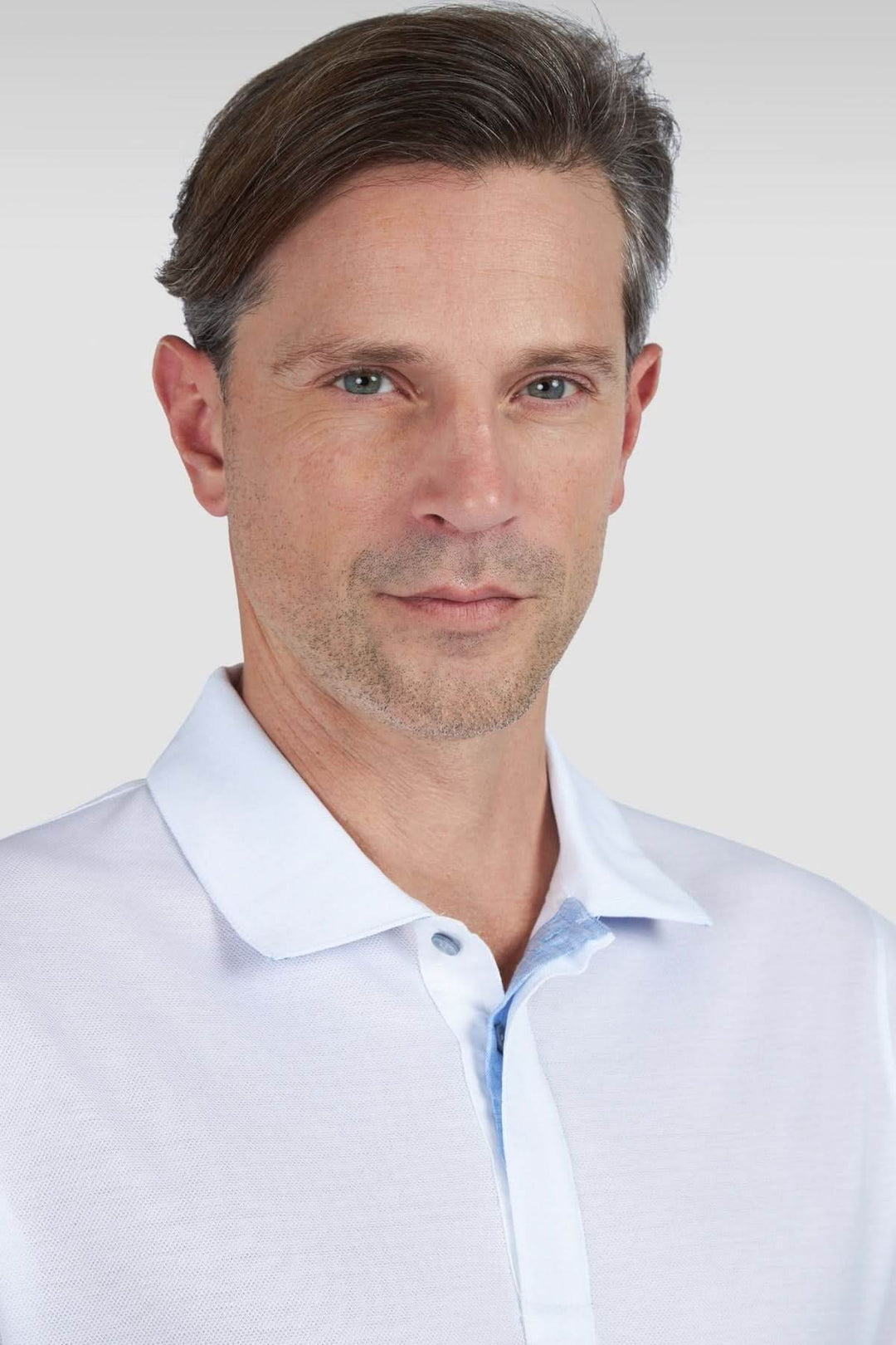 Homme portant un polo en coton piqué avec des rayures dégradées, style élégant et décontracté.