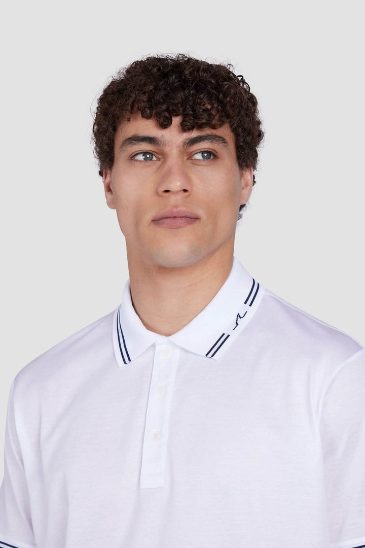 Homme portant un polo en coton avec col contrastant et aileron de requin brodé, idéal pour une tenue estivale raffinée.