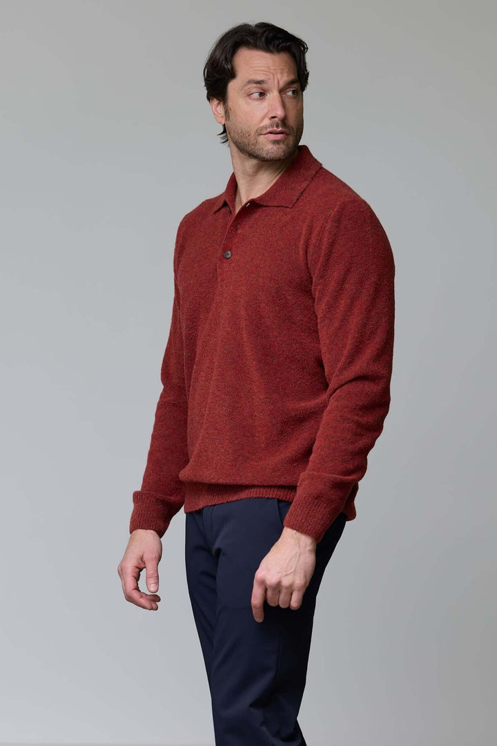 Homme portant un polo en laine mérinos rouge, élégant et confortable, avec col classique à trois boutons et coupe ajustée.